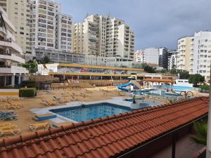 uitzicht op een zwembad in een stad met hoge gebouwen bij Portimão Appartement clube praia da rocha in Portimão