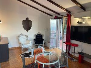 - un salon avec une table, des chaises et une télévision dans l'établissement CASA ACAMPORA, à Sorrente