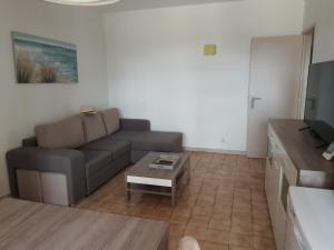 een woonkamer met een bank en een salontafel bij Portimão Appartement clube praia da rocha in Portimão