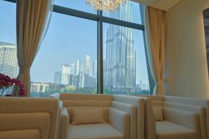 a living room with a couch and a large window at Magnificent 3 BR Luxury Apartment with Burj Khalifa View in Dubai