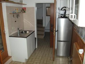 een kleine keuken met een wastafel en een koelkast bij Helle große Souterrainwohnung mit eigenem Eingang in Unterhaching
