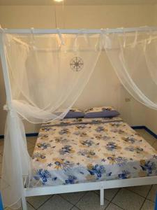 a bed with a canopy with blue flowers on it at casa in riva al lago Diletta Spiti in Castelletto sopra Ticino