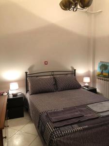 una camera con un letto con due comodini e due lampade di Διαμερίσμα σε πολυκατοικία ως ολόκληρος χώρος. a Pireo