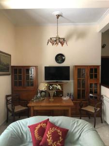 uma sala de estar com um sofá, uma mesa e uma televisão em Διαμερίσμα σε πολυκατοικία ως ολόκληρος χώρος. em Piraeus