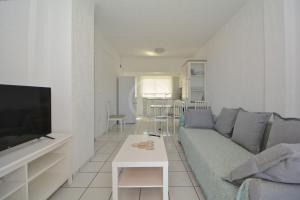 a living room with a couch and a tv at Vasiliki in Ermioni