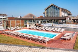une piscine avec des chaises longues et un bâtiment dans l'établissement Razelm Luxury Resort, à Jurilovca