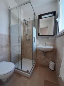 uma casa de banho com um chuveiro, um WC e um lavatório. em Trullo Tranquillo Ostuni em Ostuni