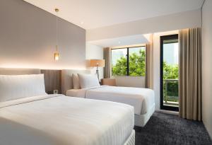 Postel nebo postele na pokoji v ubytování Oakwood Suites Kuningan Jakarta
