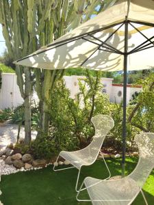 two chairs and an umbrella in a yard at Villa Cetta B&B in San Leone