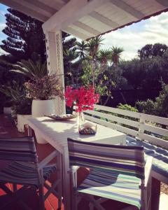 a white table with chairs and flowers on a patio at Villa Cetta B&B in San Leone