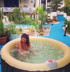 a woman sitting in a hot tub in a pool at Villa Cetta B&B in San Leone