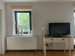 un soggiorno con TV e tavolo con TV di Ferien im Westerwald a Quirnbach