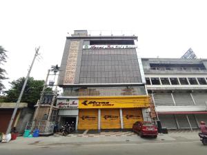 a tall building with a yellow sign in front of it at Hotel Aavas Inn in Tezpur