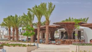 um resort com palmeiras e um restaurante em Blue Diamond Ayla - Restricted to Family stays em Aqaba