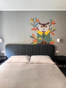 a painting of an owl on a wall above a bed at IL RICCIO Rooms in Milan