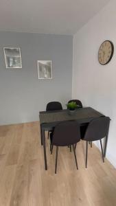 mesa de comedor con sillas y reloj en la pared en Appartement cosy et lumineux accès centre Orléans, en Orléans