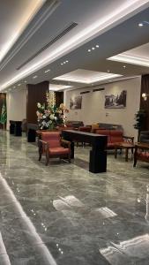 a lobby with a table and chairs and flowers at Brzeen Hotel Riyadh in Riyadh