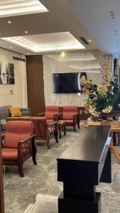a waiting room with couches and a flat screen tv at Brzeen Hotel Riyadh in Riyadh