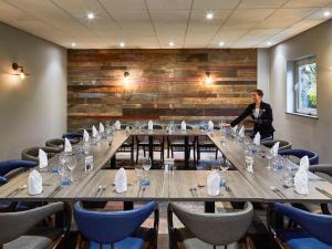 a man standing in front of a long table in a room at Novotel Wolverhampton City Centre in Wolverhampton