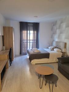 sypialnia z łóżkiem, stołem i kanapą w obiekcie Hello Málaga Loft Center Top w Maladze