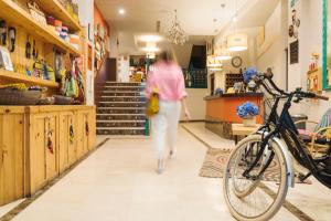 Una mujer caminando por el pasillo de una tienda con una bicicleta en Hotel San Miguel, en Gijón