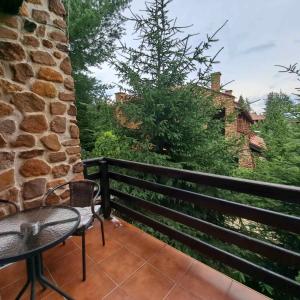 eine Terrasse mit einem Tisch und einem Stuhl auf dem Balkon in der Unterkunft Aurora Resort & Spa in Berovo