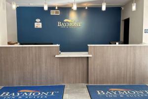 a lobby with a blue wall with a bank account counter at Baymont by Wyndham Noblesville in Noblesville