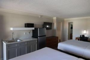 a room with a kitchen with a bed and a refrigerator at Super 8 by Wyndham Austin South I-35 in Austin