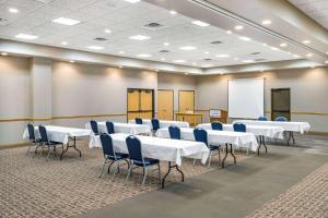 a conference room with white tables and blue chairs at AmericInn by Wyndham Aberdeen Event Center in Aberdeen