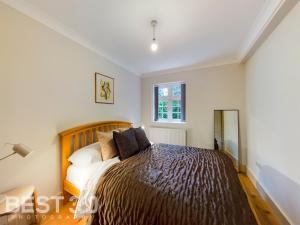 1 dormitorio con cama y ventana en Redhill town centre apartment by Livingo en Redhill