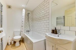 Baño blanco con lavabo y aseo en Redhill town centre apartment by Livingo en Redhill