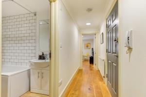 Baño blanco con lavabo y aseo en Redhill town centre apartment by Livingo en Redhill