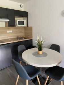a kitchen with a table and chairs and a microwave at Hotel Résidence Anglet Biarritz-Parme in Anglet