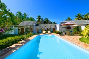 a swimming pool in front of a house at La Cocoteraie in Le Morne