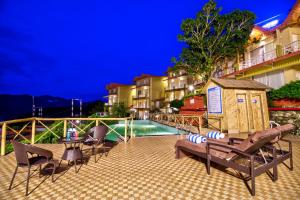 a resort with a pool and a table and chairs at Cygnett Resort Mountain Breeze in Nainital