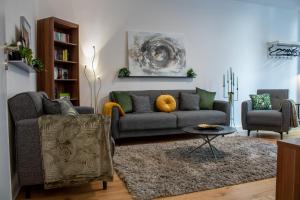 uma sala de estar com um sofá e duas cadeiras em #UrbanJungle - luxuriös - 110qm - Kicker - Streaming em Magdeburgo