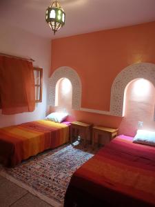 Rhorm el AlemにあるLe jardin d'habibaのアーチ2つが備わる客室で、ベッド2台が備わります。