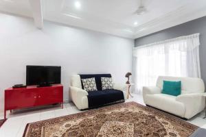 a living room with two chairs and a flat screen tv at Little Cosy House at15 in Kuala Lumpur