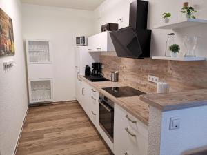 a kitchen with white cabinets and a counter top at FeWo auf der Ostsee in Olpenitz