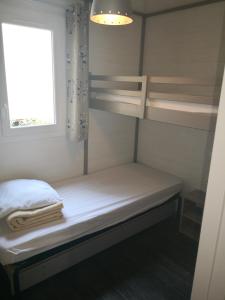 a small room with bunk beds and a window at La Colline des Ocres Village de vacances 3 étoiles in Apt