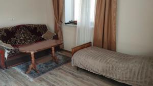a bedroom with a desk and a bed and a chair at Гостевой дом Гарни in Garni