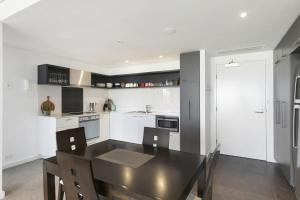 ローンにあるLorne Chalet Apartment 29のキッチン(ダイニングテーブル付)、キッチン(白いキャビネット付)