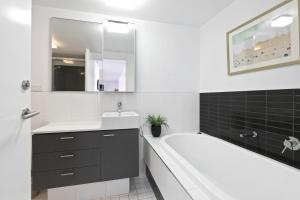 ローンにあるLorne Chalet Apartment 29の白いバスルーム(バスタブ、シンク、バスタブ付)