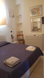 1 dormitorio con 1 cama con 2 toallas en Appartamento e Attico Epi, en Lucca Sicula