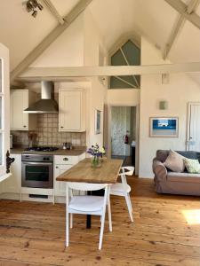 uma cozinha e sala de estar com uma mesa de madeira em Norburton Hall Cottages em Bridport