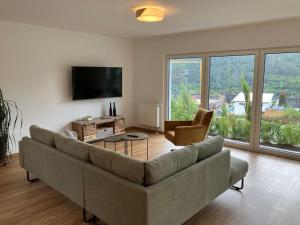 a living room with a large couch and a television at NEU - Premium-Ferienhaus MOSEL-SONNE in Traben-Trarbach