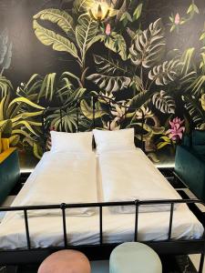 - un lit dans un dortoir avec un mur fleuri dans l'établissement Jungle Apartments, à Wrocław