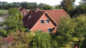 une vue aérienne sur une maison avec un toit dans l'établissement Haus Flieder, à Krummhörn