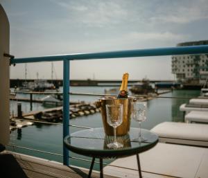 una bottiglia di champagne e bicchieri su un tavolo sul balcone di Tiny Floating Home with Marina Views a Brighton & Hove