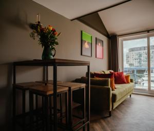 een woonkamer met een bank en een tafel met bloemen bij Tiny Floating Home with Marina Views in Brighton & Hove